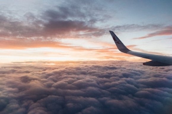 white airliner wing on top of clouds