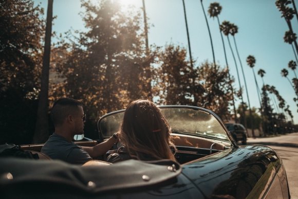 people riding convertible coupe in warm weather