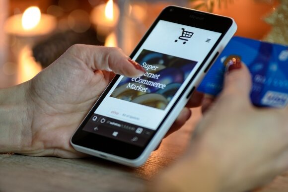 person using black and white smartphone and holding blue